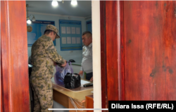 Пограничник передает в суд протоколы на трудовых мигрантов, которых обвинили в нарушении миграционного законодательства. Туркестанская область, село Сарыагаш, 4 ноября 2024 года.