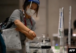 Волонтер проходит ПЦР-тестирование в главном пресс-центре, 20 июля 2021 года