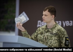 A representative of Ukraine's Center for Research on Captured and Advanced Weapons and Military Equipment, Andriy Rudyk, holds part of a Russian RG-Vo grenade