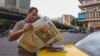 An Iranian man reads a newspaper on a Tehran street on April 12, 2025, with the front page featuring the Iran-US talks on the Iranian nuclear programme set to begin in Oman on the same day.