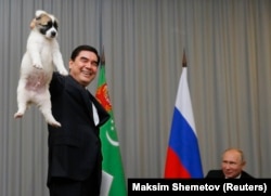 Berdymukhammedov holds up a Turkmen shepherd dog before presenting it to Russian President Vladimir Putin in Sochi in October 2017.