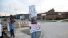 A protester holds signs outside an Immigration and Customs Enforcement (ICE) facility in Broadview, Illinois, on October 1