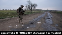 Військовослужбовець 93-ї ОМБр ЗСУ «Холодний Яр» йде повз рештки російського дрона-камікадзе неподалік Костянтинівки, Донецька область, Україна, 7 травня 2025 року