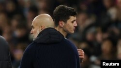 Абдукодир Хусанов (справа) и тренер ФК «Манчестер-Сити» Пеп Гвардиола во время матча клуба против «Челси», 25 января 2025 г.