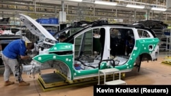 Employees work on an electric vehicle (EV) production line at a factory of Jiangling Group Electric Vehicle in Nanchang, Jiangxi Province, China.