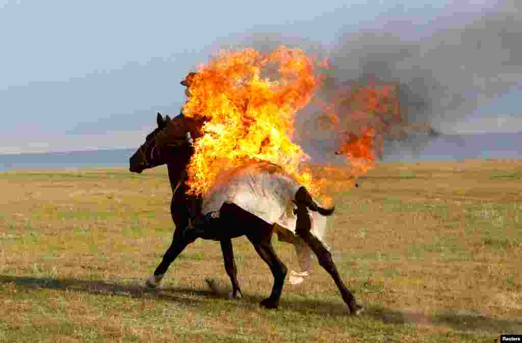Всадник выполняет трюк с огнем во время шоу Gallops, в которых принимают участие международные команды, недалеко от озера Сон-Кол в альпийской долине в Нарынской области, Кыргызстан, 21 июля 2025 года. REUTERS/Владимир Пирогов