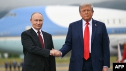 Президент США Дональд Трамп приветствует президента России Владимира Путина на взлетной полосе после их прибытия на совместную базу Элмендорф-Ричардсон в Анкоридже. Аляска, 15 августа 2025 года