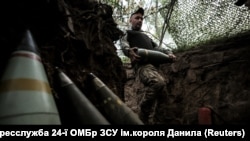 Военнослужащий 24-й ОМБр ВСУ имени короля Данила несет снаряд для самоходной гаубицы M109 на позиции вблизи Часового Яра, Донецкая область, 14 июня 2025 года.