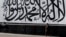  A man walks past a wall mural depicting the Taliban flag in Kabul.