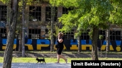 Жінка вигулює свою собаку в місті Миколаєві в час масштабного вторгнення Росії до України. Миколаїв, 24 серпня 2022 року