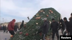 Начало кровавых событий в Жанаозене в декабре 2011 года. Неизвестные молодые люди повалили установленную на Новый год на центральной площади ёлку. 16 декабря 2011 года.