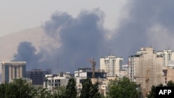 Smoke billows for the second day from the Shahran oil depot, northwest of Tehran, on June 16