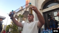 Жител на Плевен показва шишета, пълни с негодна за пиене вода, 17 август 2025 г.