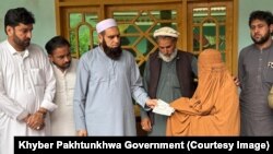 صوبايي وزير ډاکټر امجد علي يوې ښځې ته د پیسو چيک ورکوي 