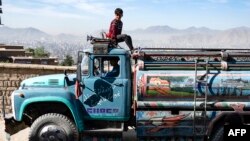 Un băiat pe cabina unui camion-cisternă la Kabul, pe 27 aprilie 2025.