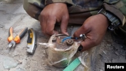 Член группы по разминированию сепаратистской Ливийской национальной армии обезвреживает мину в Бенгази. Ливия, 14 января 2018 года