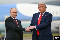 Президент США Дональд Трамп приветствует главу России Владимира Путина на взлетно-посадочной полосе в Анкоридже, Аляска, 15 августа 2025 года