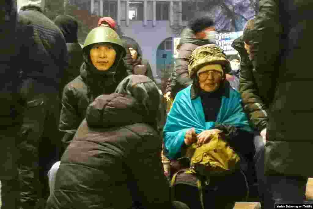 Protesters wearing military-style helmets in Almaty on January 5.&nbsp;