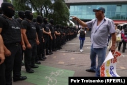 Участник протестной акции пытается разговаривать с полицейскими. Алматы, 6 июля 2021 года