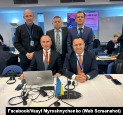 Леонід Пшеничнов (стоїть у центрі), біолог, Василь Мирошниченко, посол України в Австралії (сидить праворуч) на одному із засідань CCAMLR. Архів