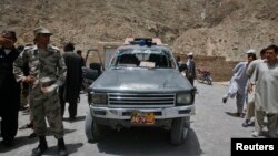 امنیتي سرتېري او خلک په کوټه کې تر برید وروسته د پولیسو زیانمن شوي ګاډي جاج اخلي - انځور له ارشیفه. 