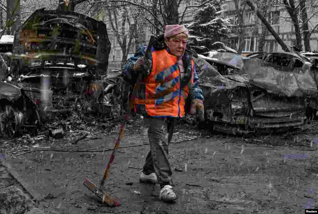 Урам себерүче Украинаның Днепр шәһәрендә Русия дроны һөҗүм иткән урынны чистарта, 9 апрель.