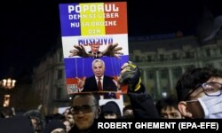 Плакат, на якому зображений керівник Росії Володимир Путін і Келін Джорджеску, який пройшов до другого туру на виборах президента Румунії, на акції протесту в румунській столиці. Бухарест, 25 листопада 2024 року