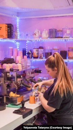 Працівниця готує каву