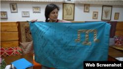 Леране Хайбуллаєва з кримськотатарським прапором