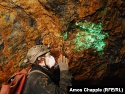 Радиоактивные кристаллы отенита видны под ультрафиолетовым светом фонарика в заброшенной урановой шахте в Южной Богемии