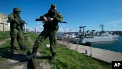 Russian soldiers guard a pier where two Ukrainian naval vessels are moored in Sevastopol, Ukraine, in March 2014.