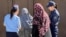 Female police officers in Osh speak to local women during a raid to enforce the niqab ban.