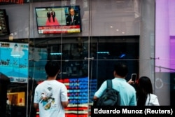 Люди смотрят встречe президента США Дональда Трампа с президентом России Владимиром Путиным на Аляске, Нью-Йорк, 15 августа 2025 года