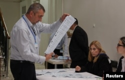 Сотрудник избирательной комиссии в Кишеневе с бюллетенем дл выборов депутатов парламента страны, 28 сентября 2025 года