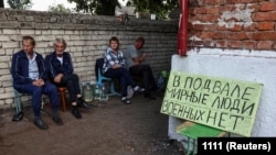 Курскиде бомбадан корголоочу жайдын жанында отурган карапайым тургундар. 16-октябрь, 2024-жыл.