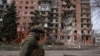 A Ukrainian soldier passes a residential building damaged by Russian military strikes in the frontline town of Pokrovsk on March 6.