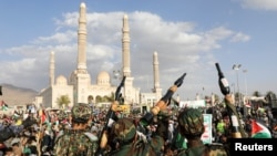 Дети в камуфляже держат в руках макеты РПГ, в то время как взрослые хуситы собираются почтить память 10 своих бойцов, погибших в результате удара ВМС США в Красном море. Сана, Йемен, 5 января 2024 года.