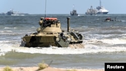 Российский бронетранспортер БТР-82А выезжает на берег во время военных учений, известных как «Центр-2019», на полигоне «Турали» на побережье Каспийского моря. Дагестан, Россия, 20 сентября 2019 года