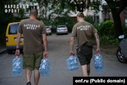 Активісти російської провладної організації «Народний фронт» розносять питну воду жителям окупованих регіонів Донбасу під час водної кризи, серпень 2025 року