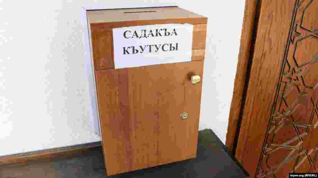 Sadaqa qutusı. Er adam aqça qaldıra bile