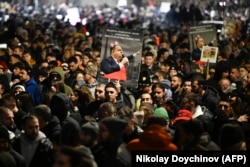 Протестувальники тримають плакати із зображенням болгарського політика Деляна Пеєвського під час антиурядових протестів у Софії 1 грудня 2025 року