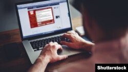 Компьютерде WannaCrypt вирусы скриншотын жасап отырған адам.  