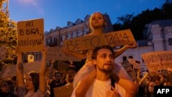 Әкесінің мойнына отырған қыз НАБУ мен САП қызметінің тәуелсіздігін шектейтін заңға вето қоюды талап етіп тұр. Киев, 24 шілде 2025 жыл.