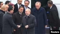 Türkmenistanyň prezidenti Serdar Berdimuhamedow (çepde) Russiýanyň prezidenti Wladimir Putini garşylaýar. Aşgabat, 12-nji dekabr 