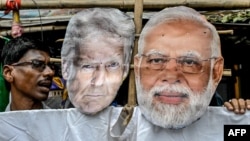 Activists carry an effigy of US President Donald Trump and Indian Prime Minister Narendra Modi as they protest against US tariffs.