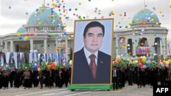 Türkmenistanda döwletiň guramaçylygyndaky baýramçylyk çärä gatnaşýan adamlar prezident Gurbanguly Berdimuhamedowyň portretini göterýär